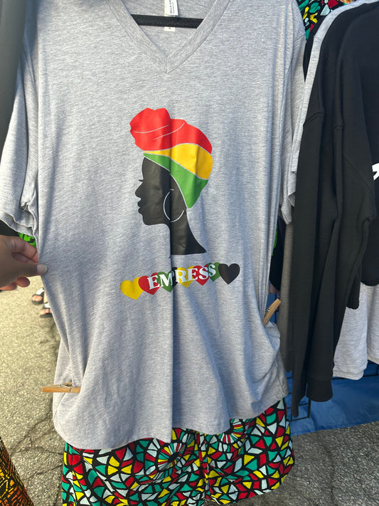 Heather Grey V-neck shirt with black woman silhouette with red, yellow and green headwrap. Below the silhouette hearts yellow, red, green and black repeatedly with word Empress in white. Melanin apparel.