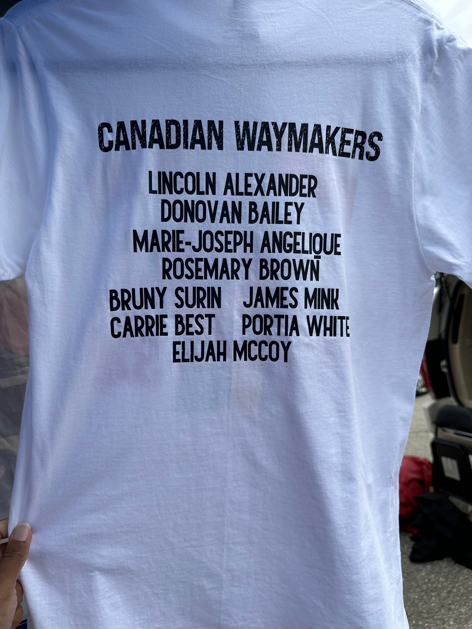 The back of the shirt honors notable Canadian Waymakers, including Lincoln Alexander, Donovan Bailey, Marie-Joseph Angelique, Rosemary Brown, Bruny Surin, James Mink, Carrie Best, Portia White, and Elijah McCoy, celebrating their significant contributions and the perseverance of Black communities in Canada in black text. Melanin Apparel.