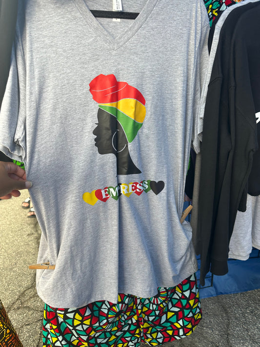 Heather Grey V-neck shirt with black woman silhouette with red, yellow and green headwrap. Below the silhouette hearts yellow, red, green and black repeatedly with word Empress in white. Melanin apparel. 