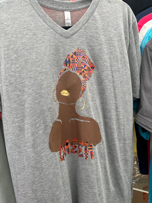 Heather grey V-neck shirt with silhouette of a black woman in brown staring up with gold earrings and gold lips with Ankara headwrap and word queen in matching Ankara print. Melanin Apparel. 