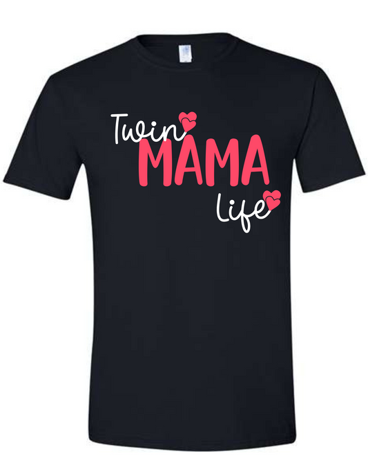 Black shirt with Pink Mama text bold in the centre and twin in script text at the top and life under Mama in white with double hearts at end of twin and life in pink.